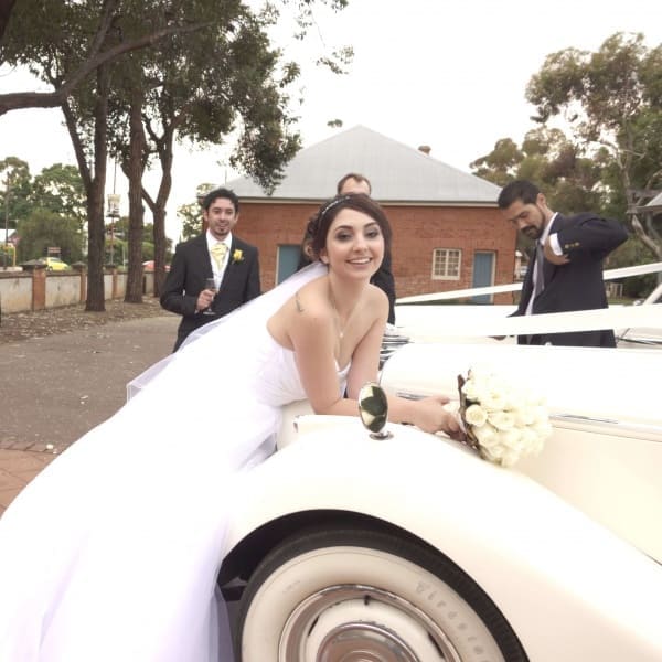 Bride leaning over a Jaguar Mk 5 sedan
