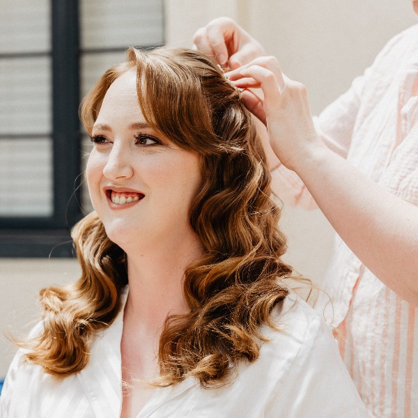 Bold eye makeup with a half up waved hairstyle