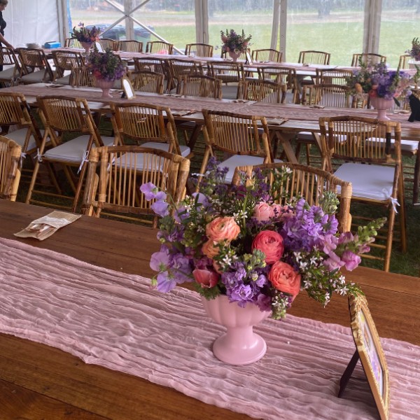 Long wooden trestle tables and bamboo chairs for a marquee reception