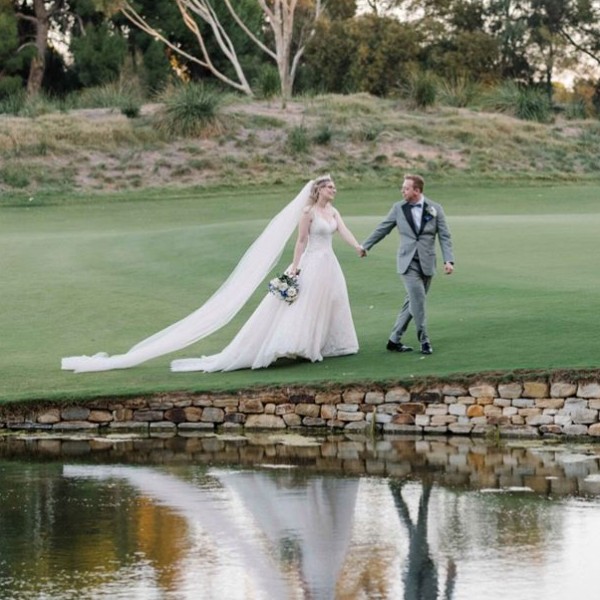 Bride and groom walking along lake