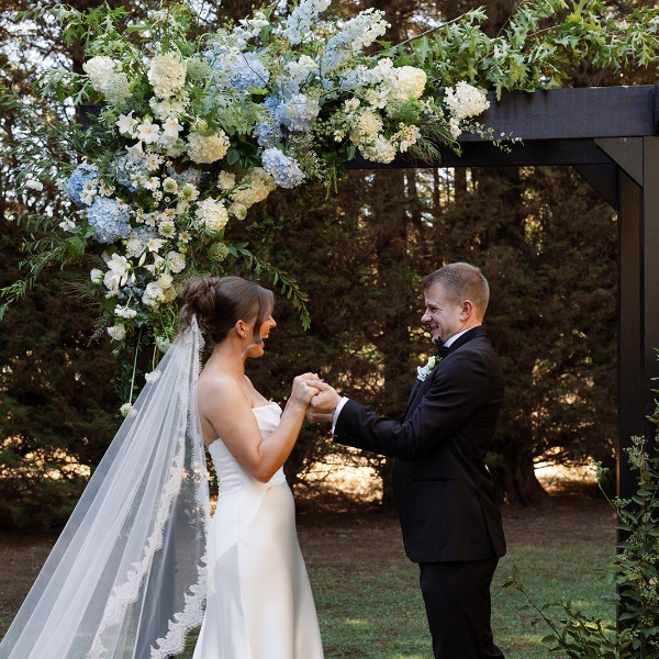 Bride and Groom under floral arch ceremony flowers Lillypad Flowers, hydrangea, scabiosa, queen annes lace, cosmos