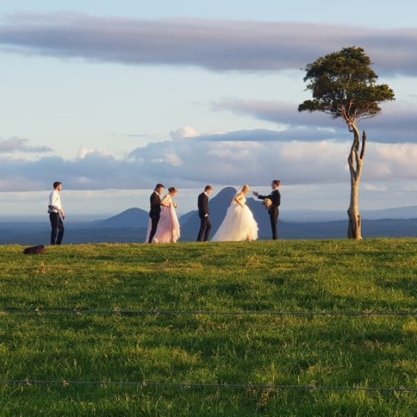 A bridal party captures stunning offsite photographs overlooking the Glass House Mountains