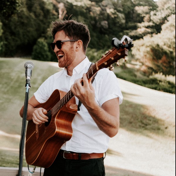 Kristen plays guitar as bride and groom enjoy themselves at an intimate elopement ceremony